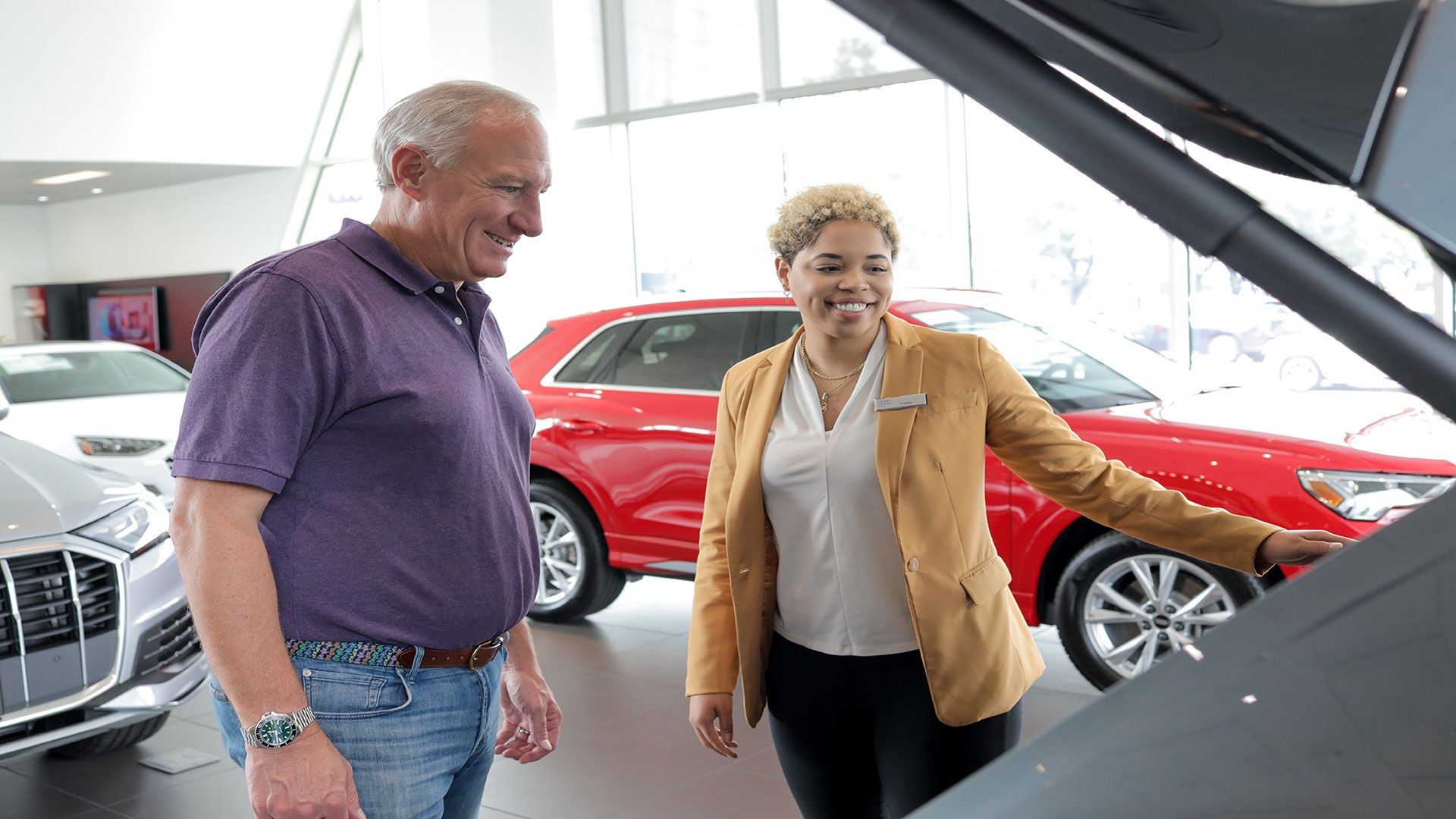 Audi employee showing the vehicle features to a customer.