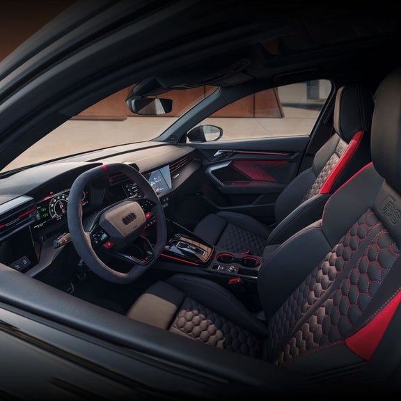 Interior cabin view of the Audi RS 3, showing the front sport seats, steering wheel, and center console. 