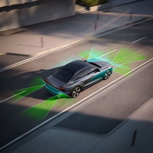 Birds-eye view of the Audi A6 Sedan in motion with beams of light depicting sensors.