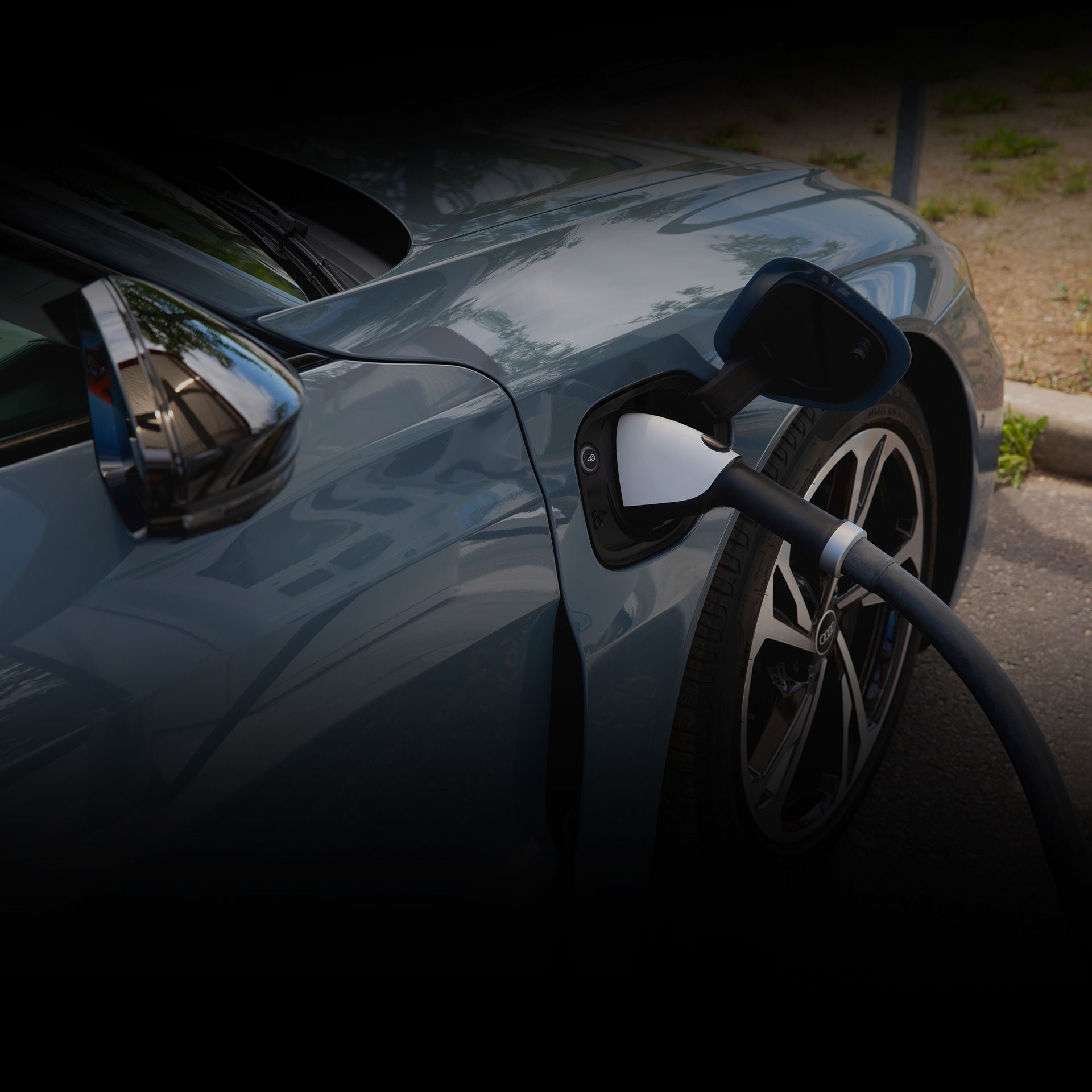 Close-up of a charging cord hooked up to the charging port of an Audi e-tron vehicle.