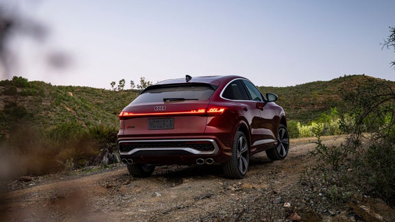 Three-quarter rear view of an Audi SQ5 parked on a gravel surface.