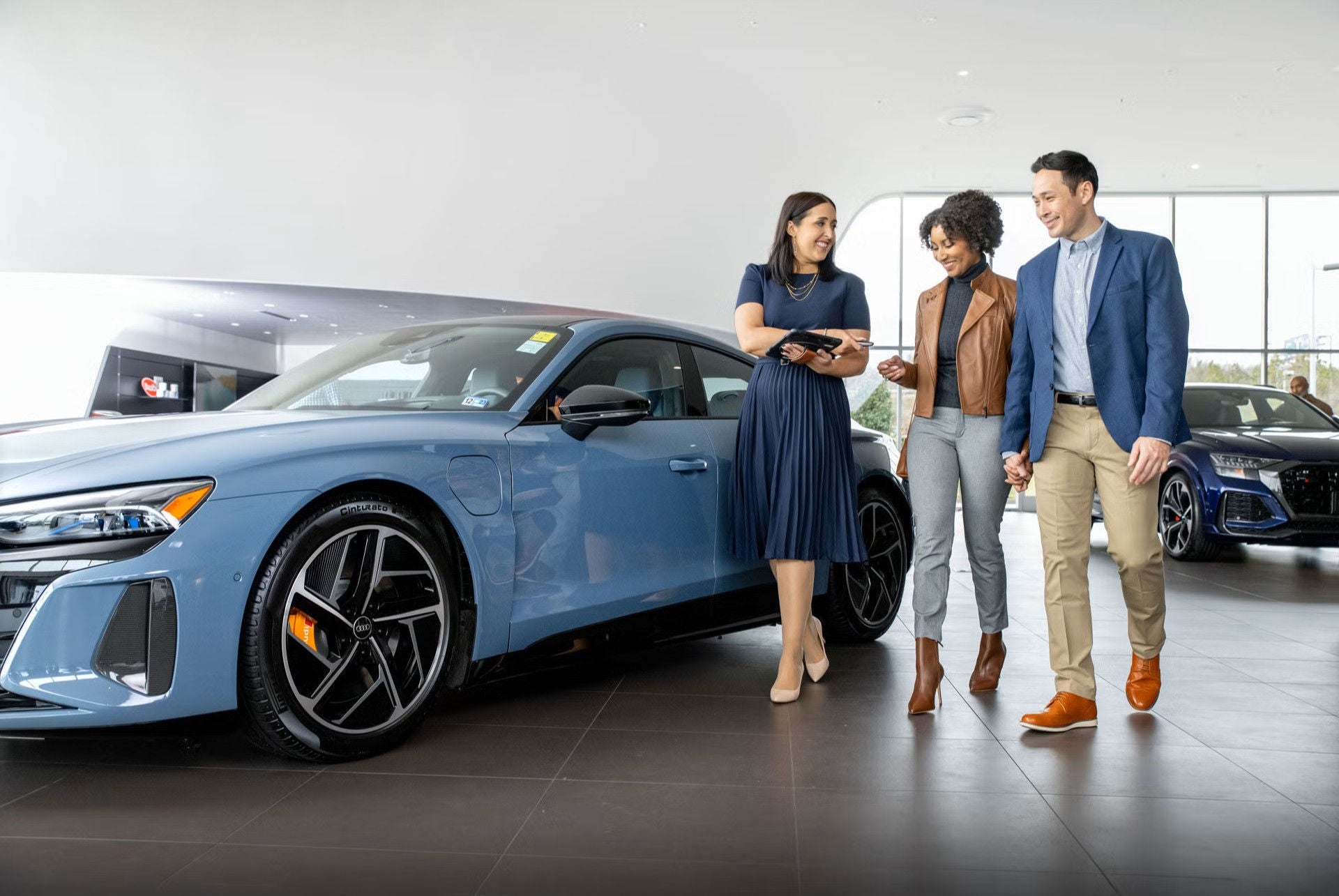 Audi Salesperson talking to happy couple interested in electric Audi vehicle