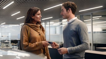An Audi dealer handing over a set of keys to an Audi customer.