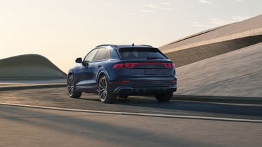 Vue de trois-quarts arrière de l'Audi Q8 en mouvement.