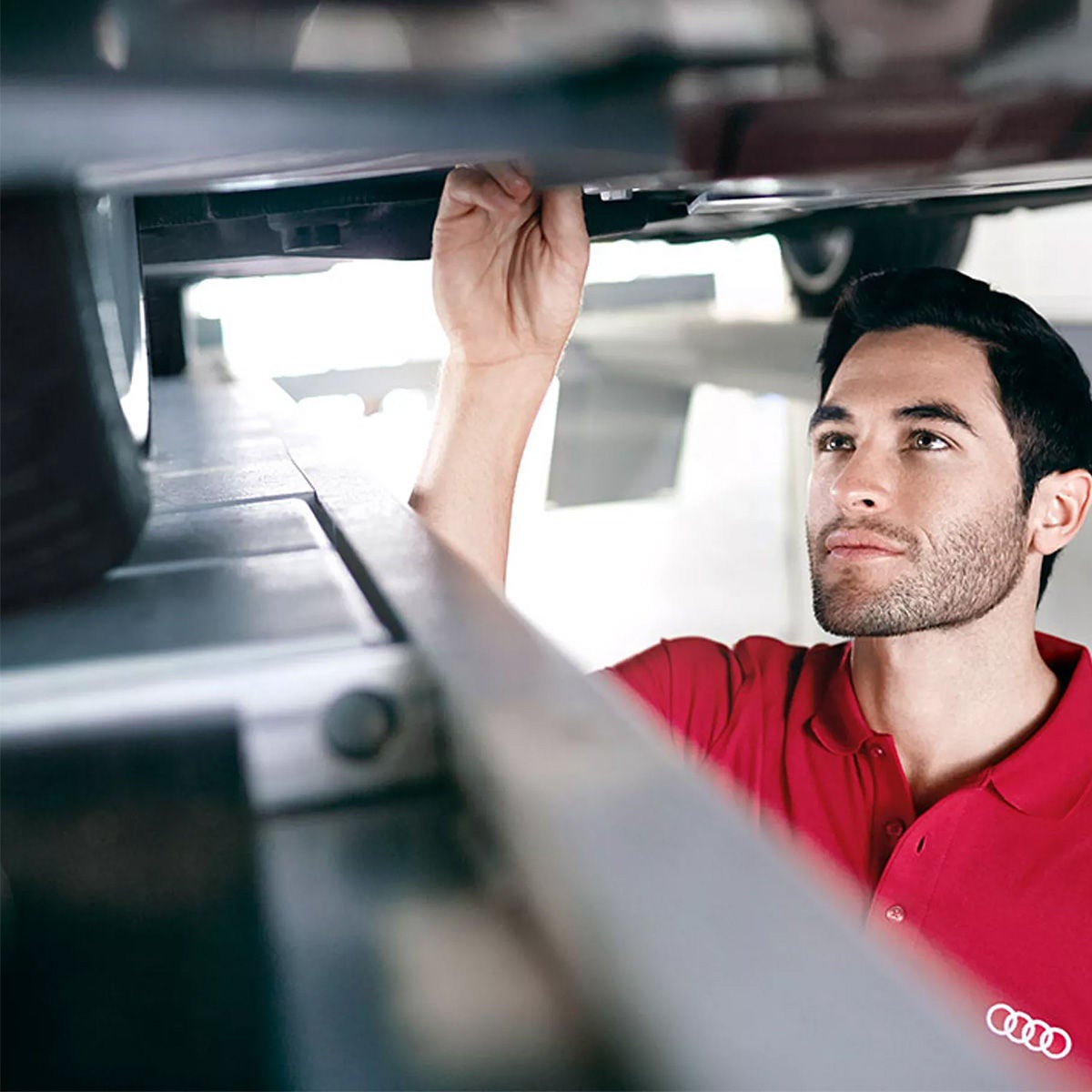 Audi service tech checking under a vehicle