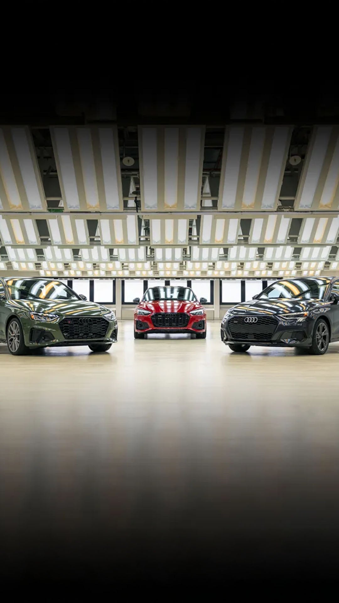 Three Audi vehicles parked facing each other.