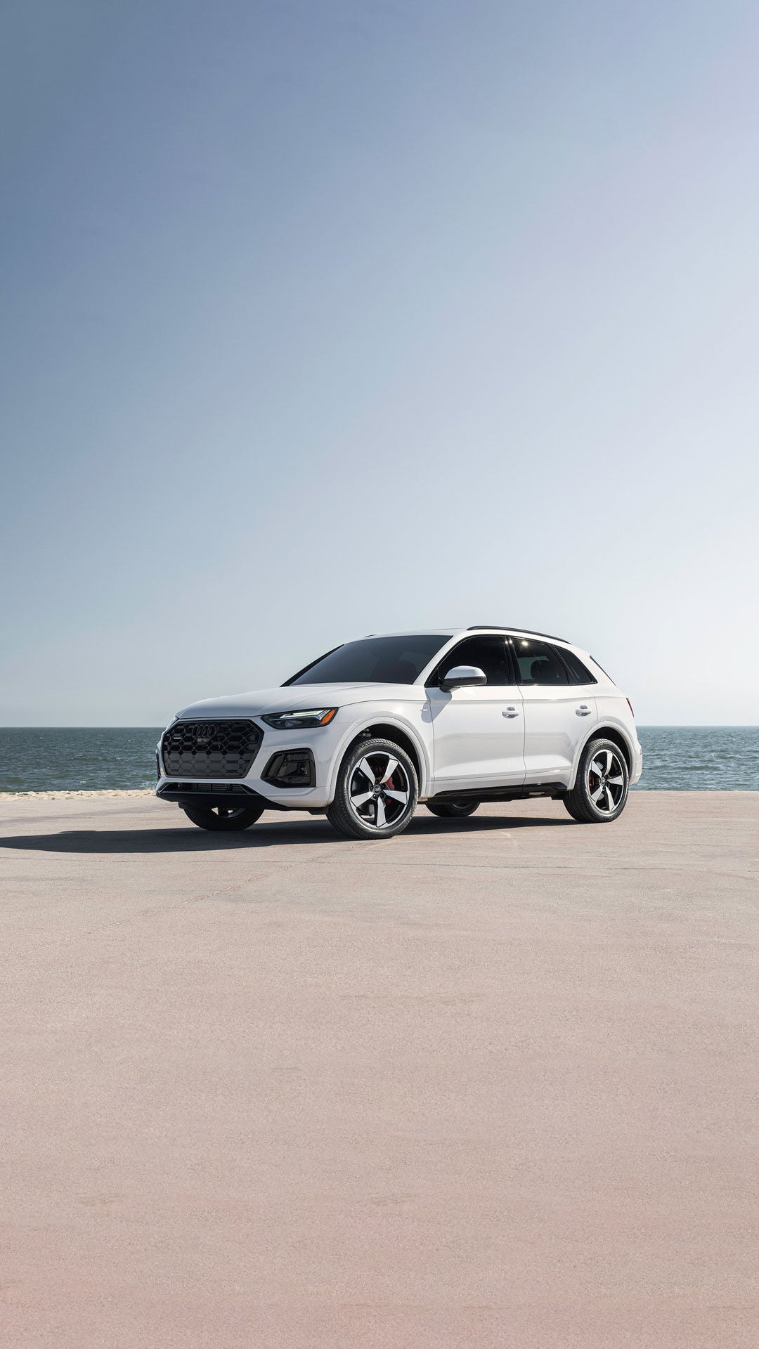 Vue de trois quarts avant d'une Audi Q5 garée au bord d'un quai.