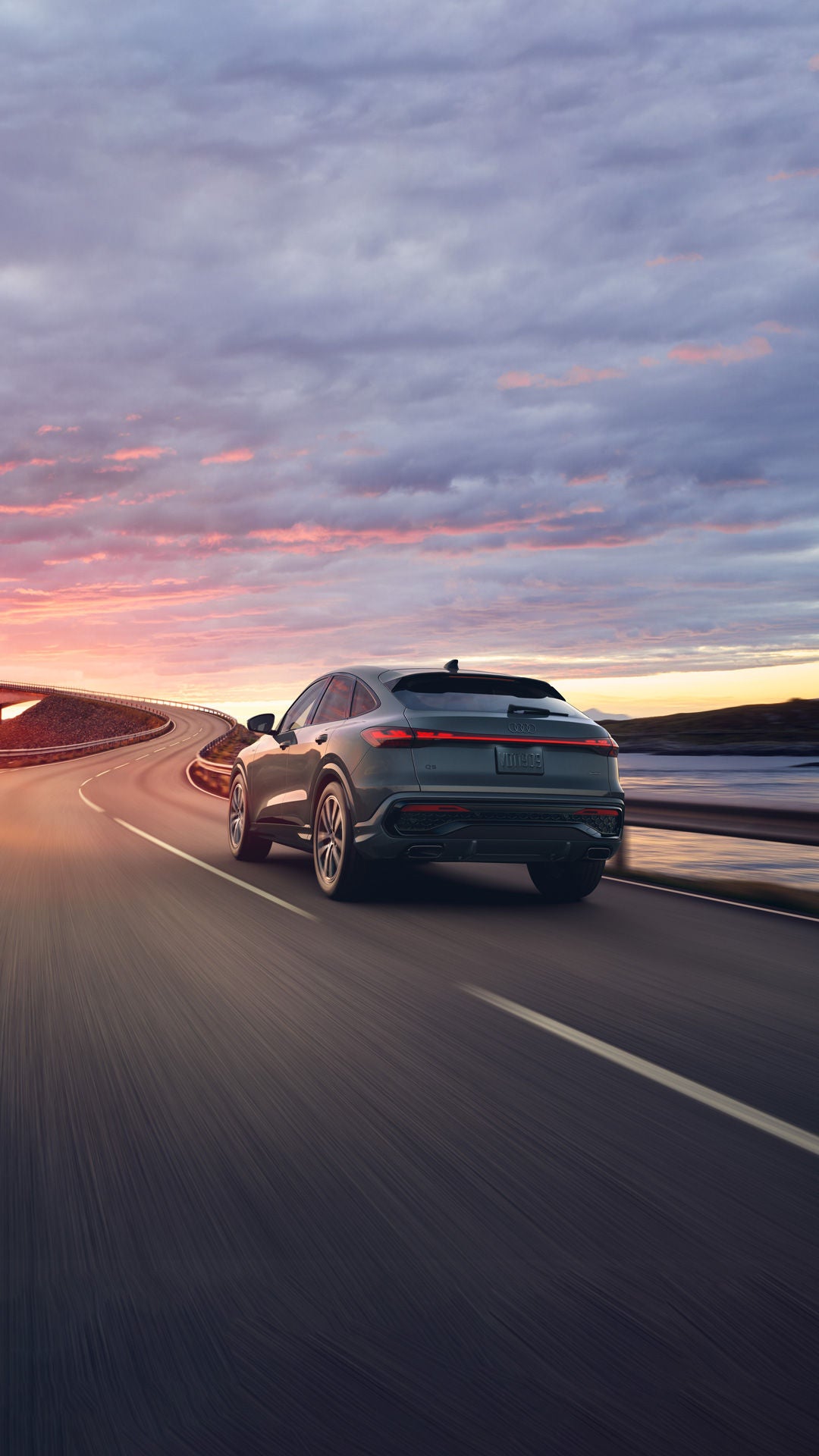Three-quarter rear view of the Audi Q5 Sportback accelerating on a highway bridge.