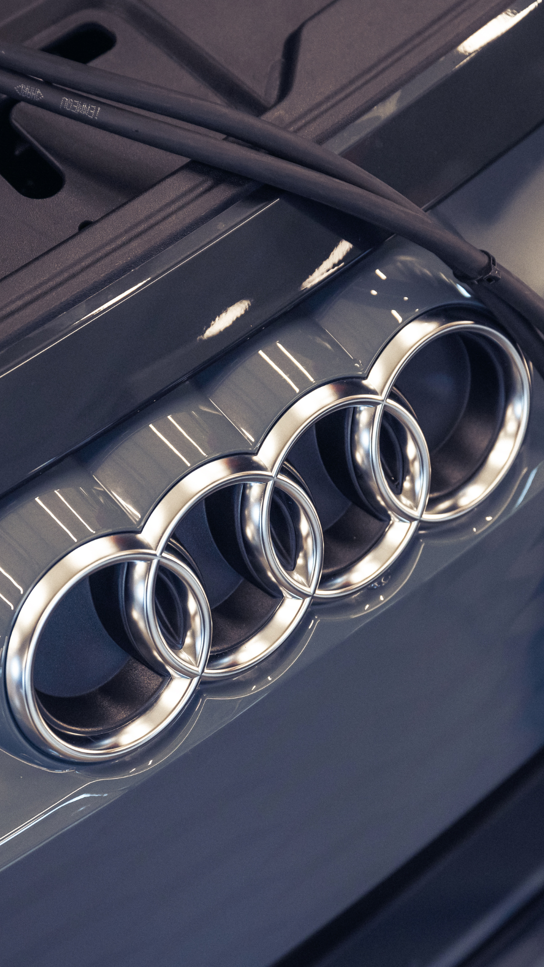 Audi car with an open hood, showing the Audi rings emblem closely.