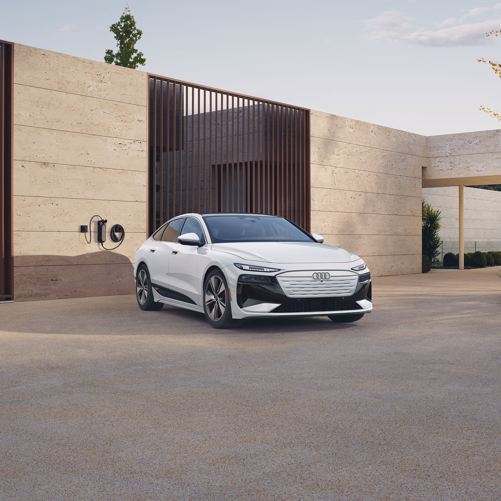 Three-quarter front view of the Audi A6 e-tron parked and charging.