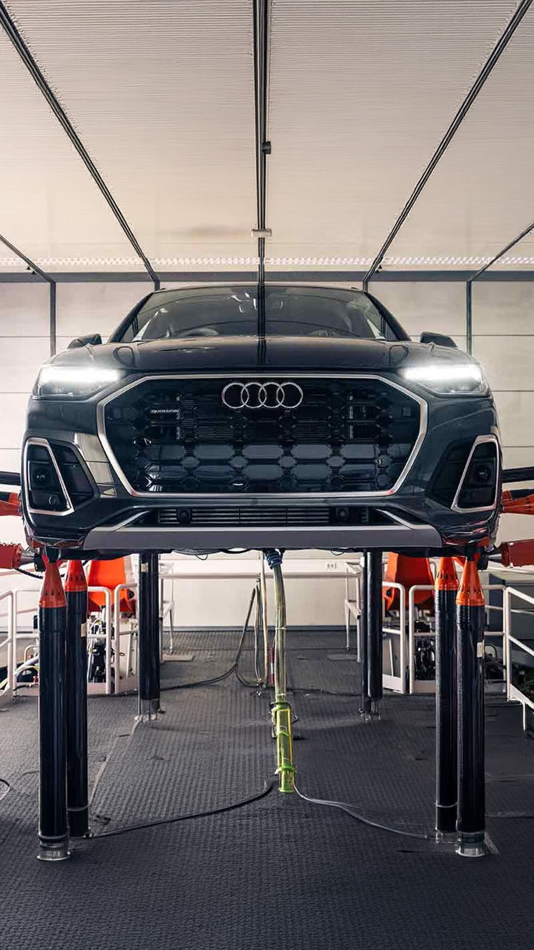 Audi service tech under the hood of a vehicle