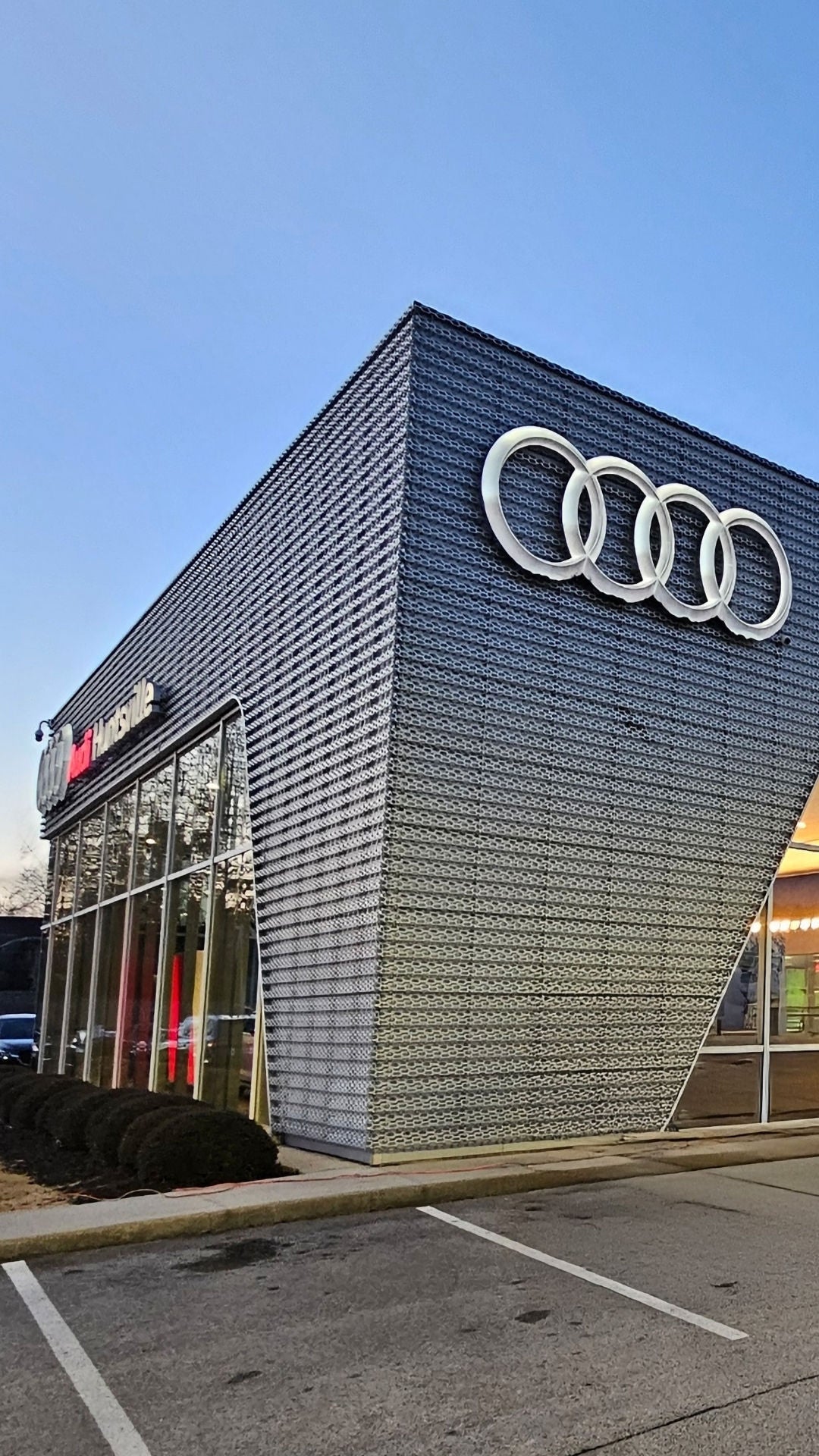 Front profile view of the Audi Huntsville dealership in the sunset.