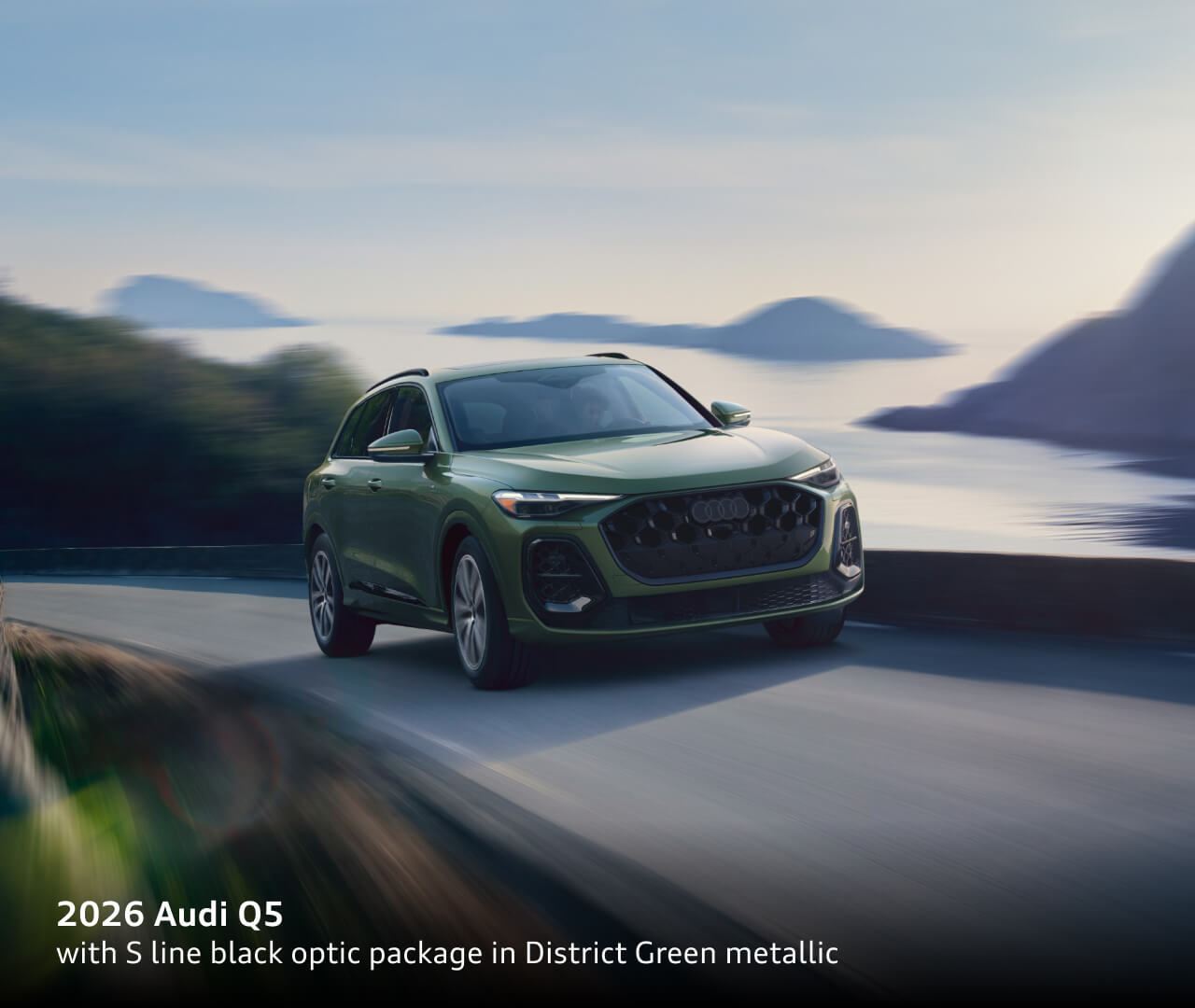 2026 Audi Q5 Prestige TFSI® quattro® S tronic® with S line black optic package in District Green metallic driving through a coastal landscape