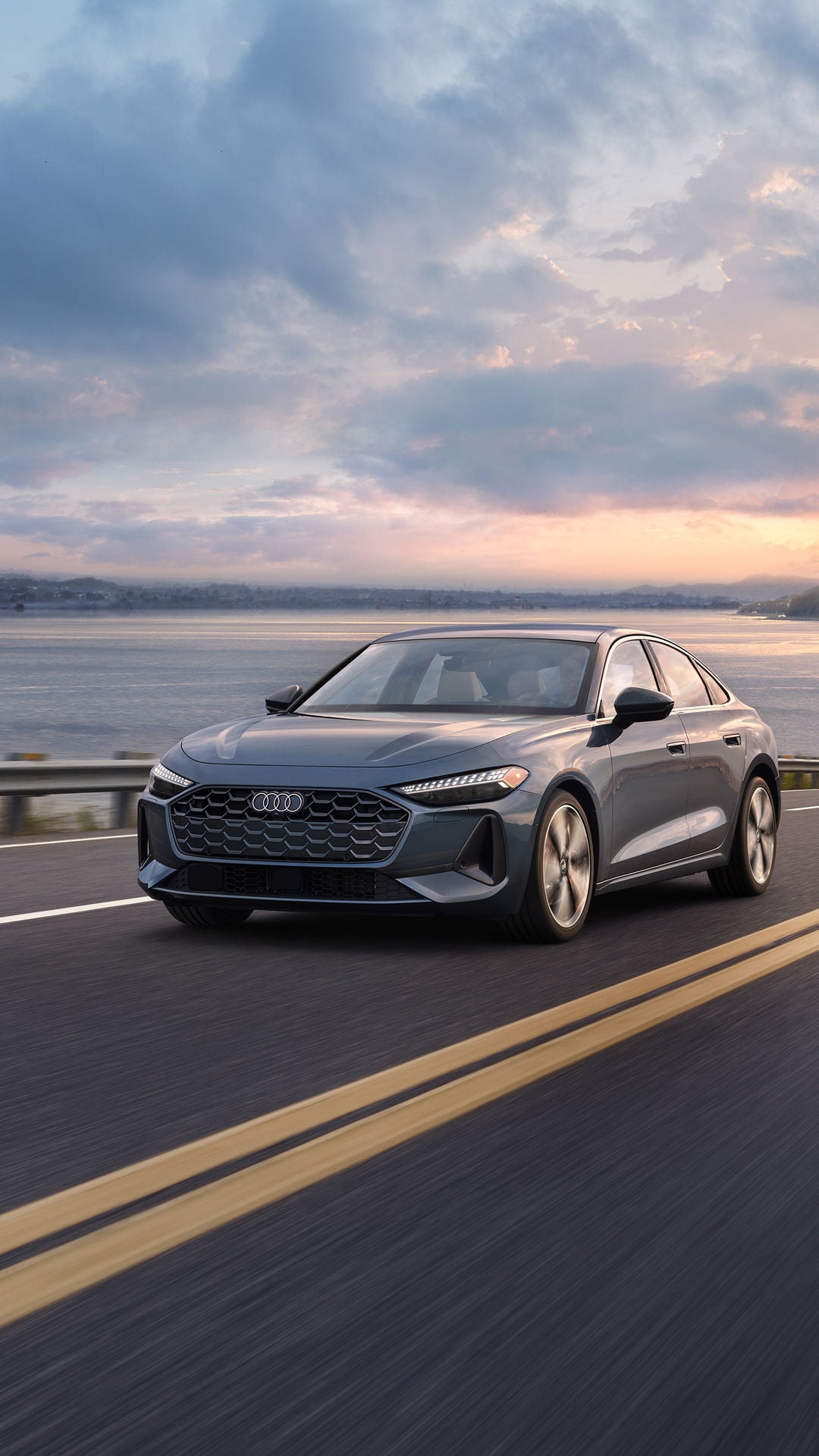 All-new Audi A5 driving on a road with a scenic background.