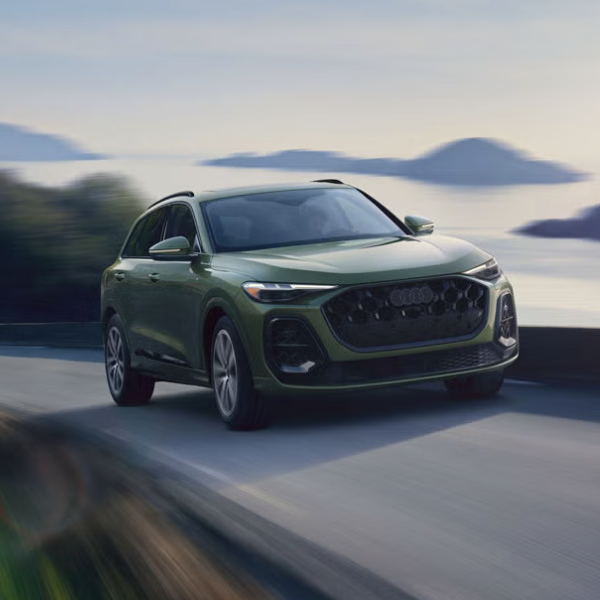 2026 Audi Q5 SUV driving on road with mountains and the sea in background