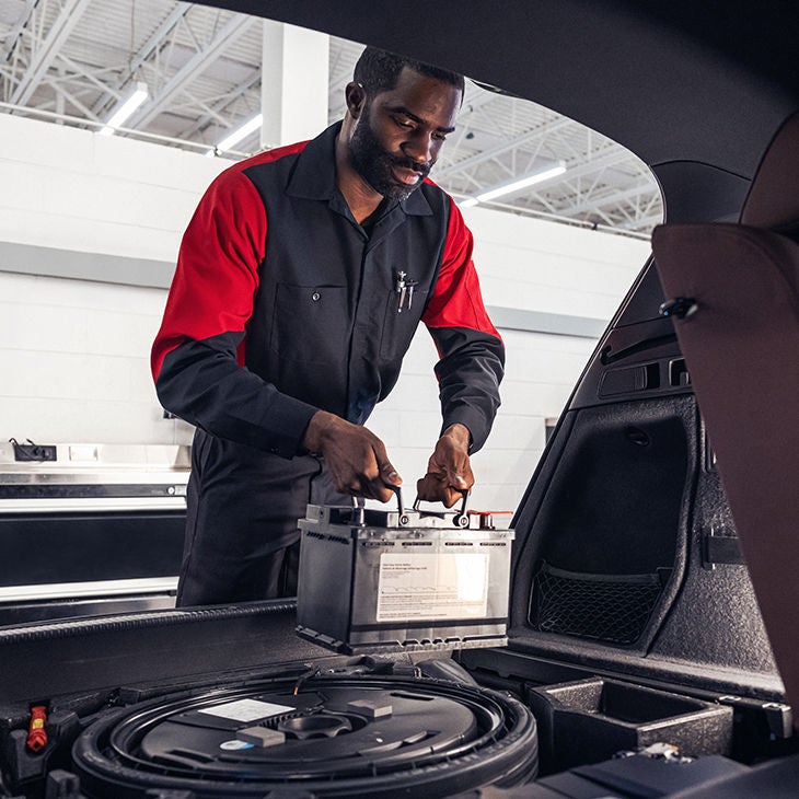 An Audi technician installing a battery part into an Audi EV.
