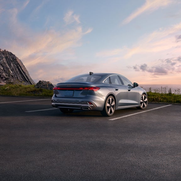 Three-quarter rear view of the all-new Audi A5 parked on an overlook.