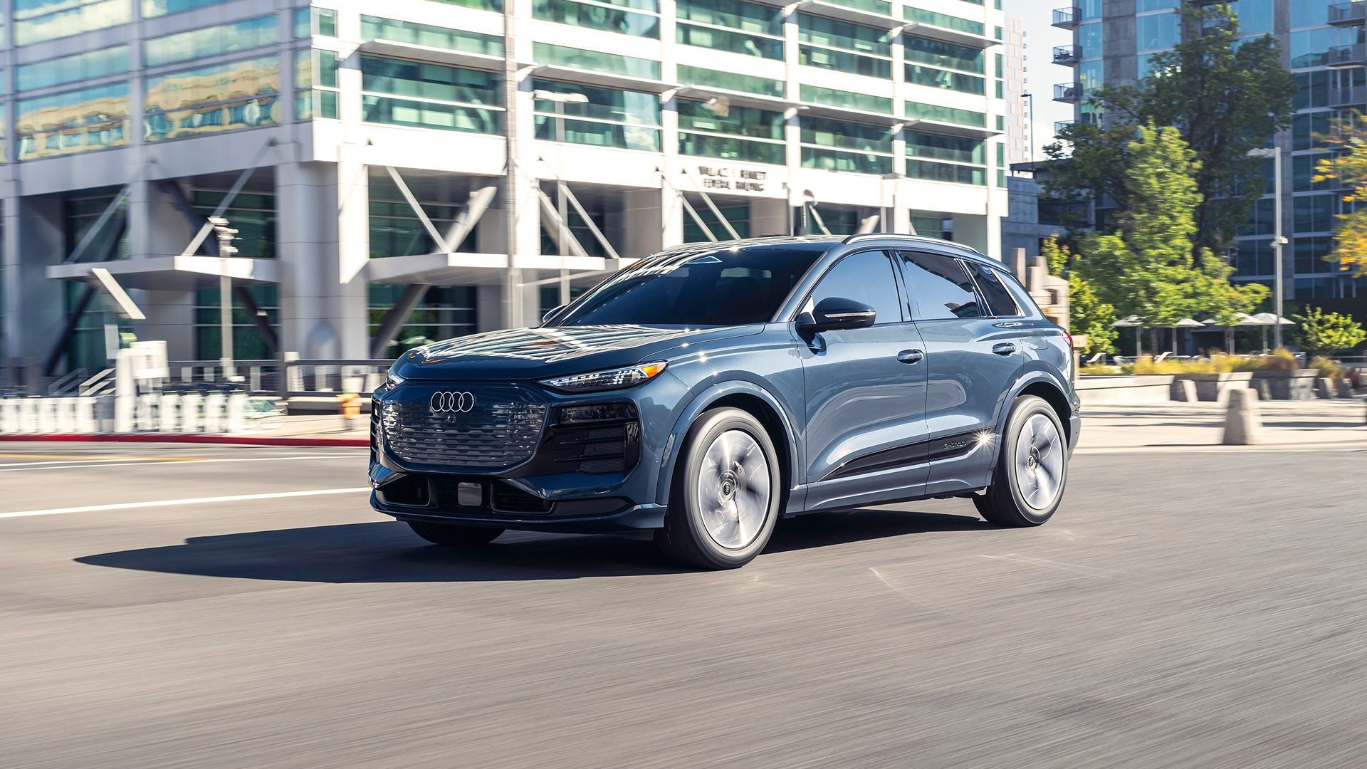 Audi Q6 e-tron crossing a downtown intersection