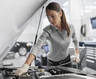 Service technician servicing vehicle.
