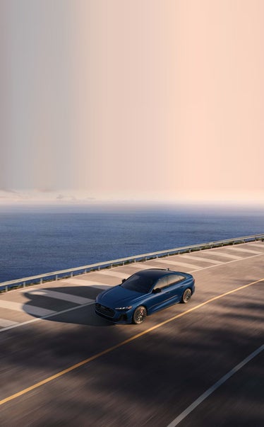 2026 Audi S5 Sportback driving along a coastal causeway