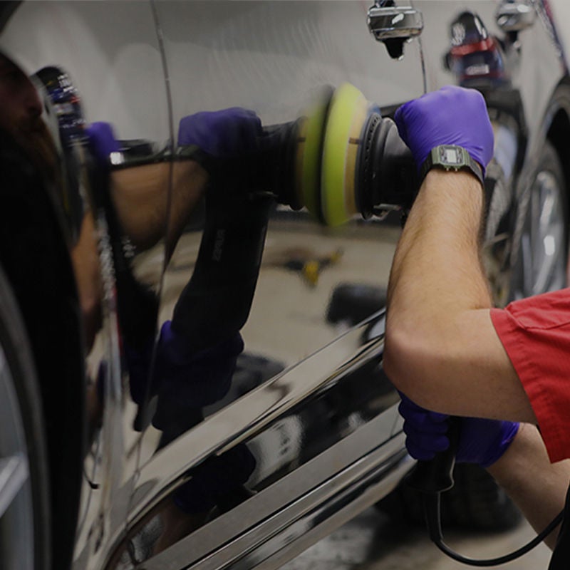 a detailer buffing the side panel of an Audi 