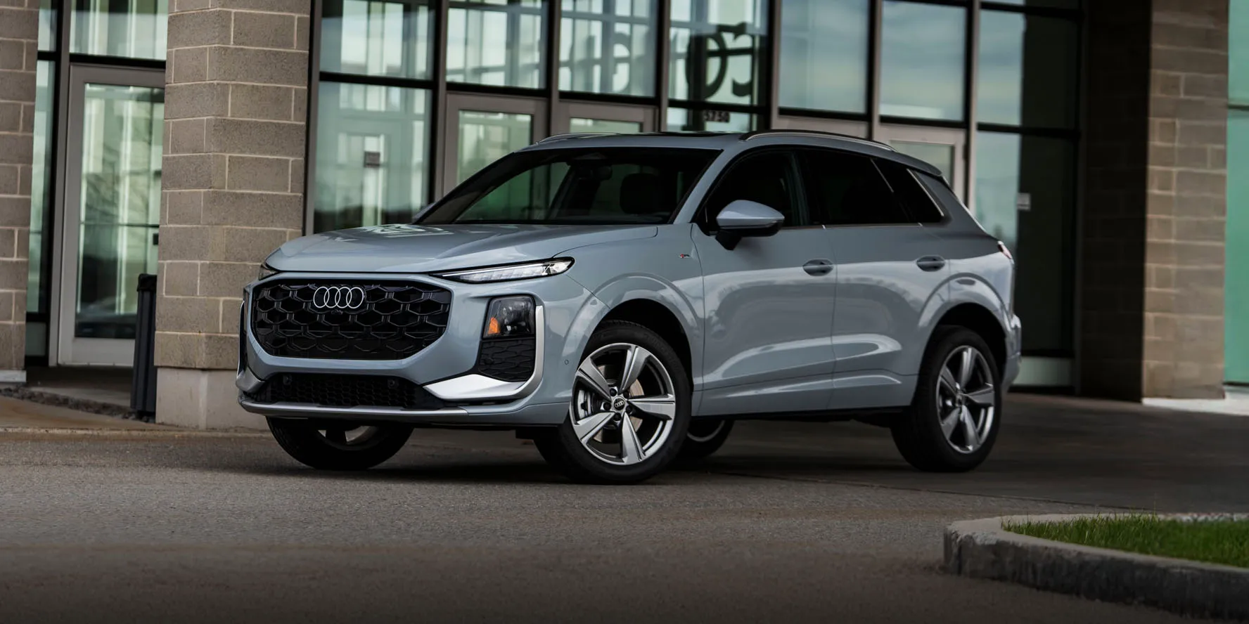 Vue de face de l'Audi Q3 2026 couleur argent, stationnée devant un commerce - Audi Lévis 