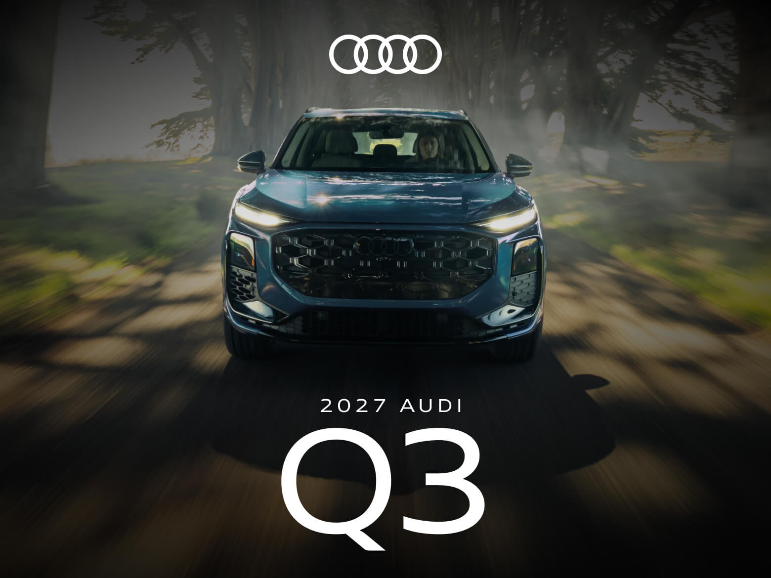 Front exterior action shot of a dark blue 2027 Audi Q3 driving down a tree-lined road.