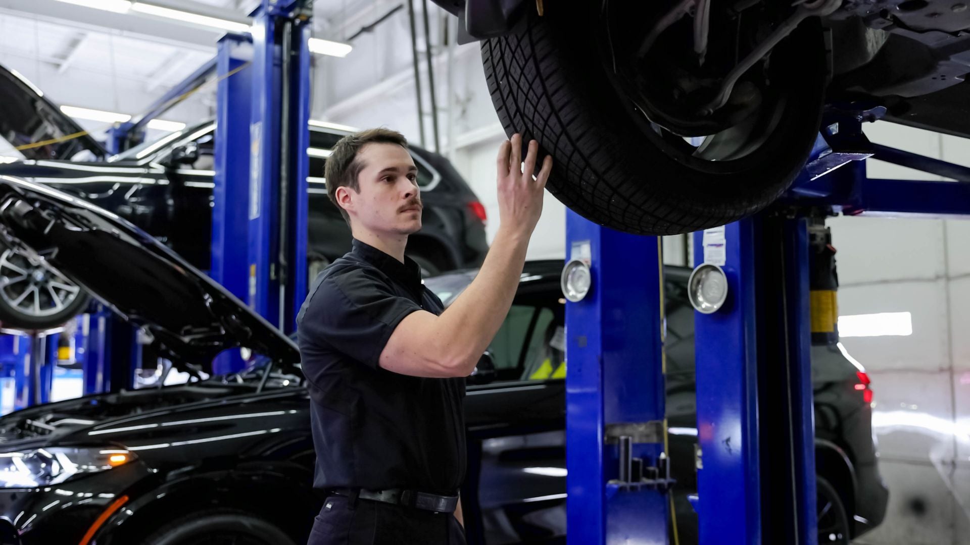 Audi service technician servicing a vehicle.