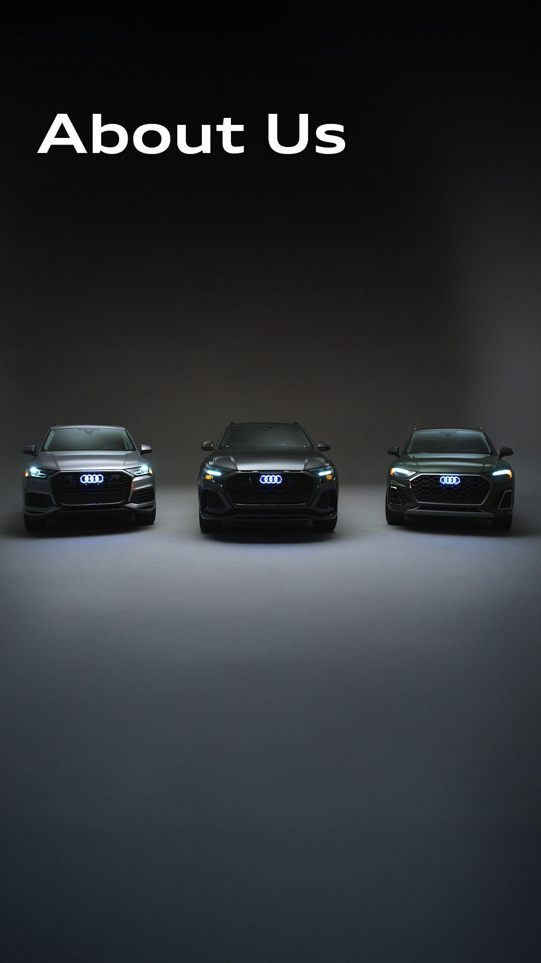 Three Audi cars parked side by side in a showroom-style garage