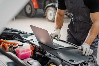 Mechanic using a computer in an engine bay