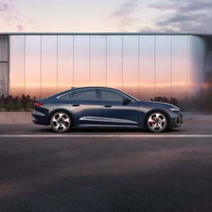 Exterior shot of an Audi A5 parked by a building.