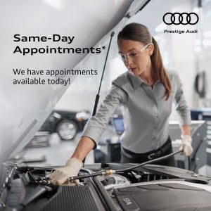 Audi technician under the hood of a vehicle