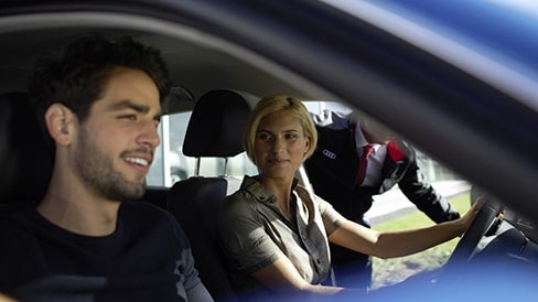 A man and a woman sitting in an Audi vehicle. 