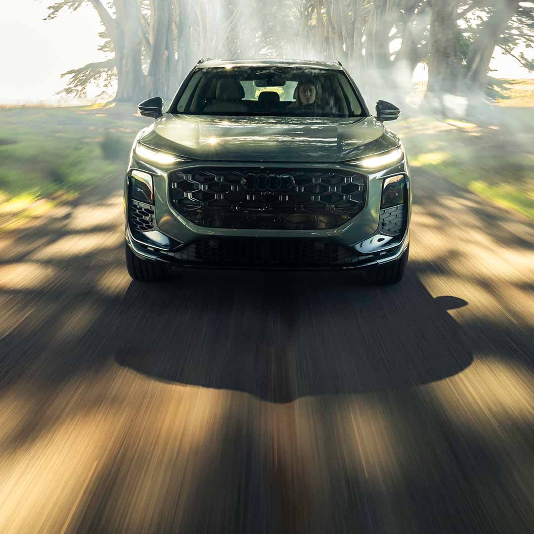 Left profile view of an Audi Q7 accelerating.