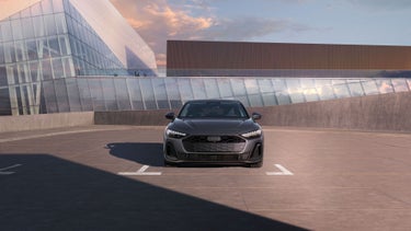 Front profile of the Audi A5 parked by a modern building.