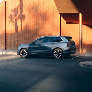 Three-quarter side view of the Audi Q7 parked by a modern building.