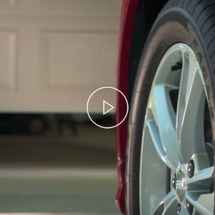 Close-up of the wheel of an Audi vehicle entering a home garage.