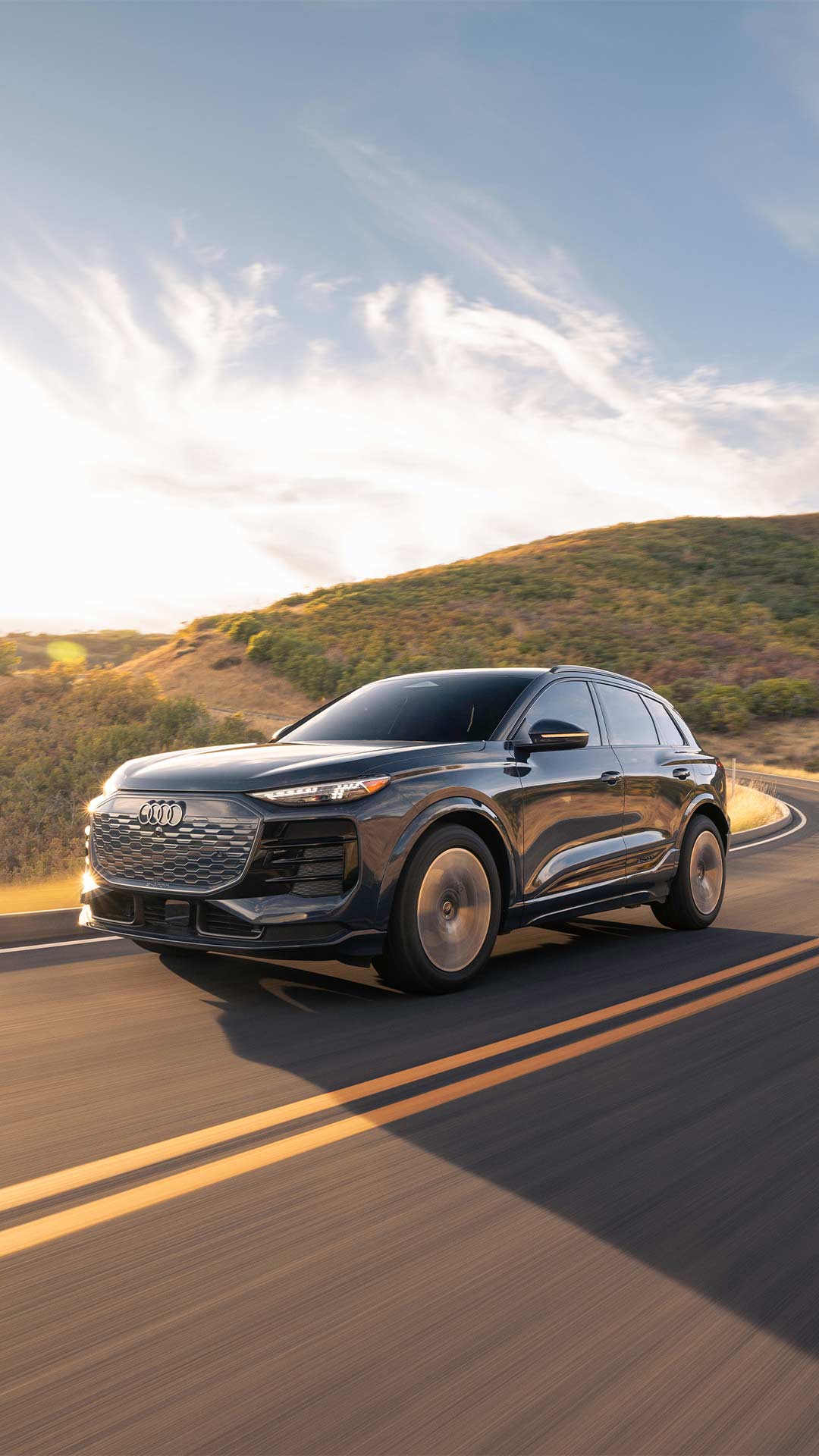 Three quarter profile view of an Audi Q6 accelerating.
