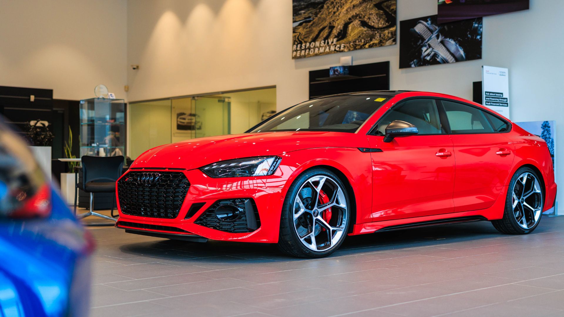 Red Audi car parked inside the showroom of Audi Asheville