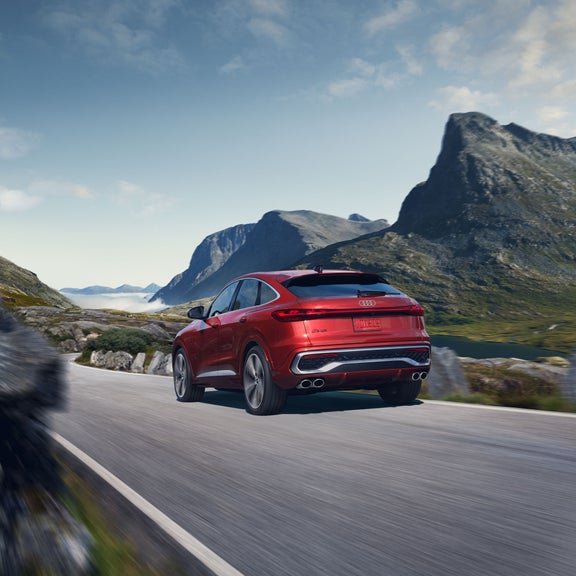 Vue trois quarts arrière de la toute nouvelle Audi SQ5 Sportback en mouvement sur une route de montagne.