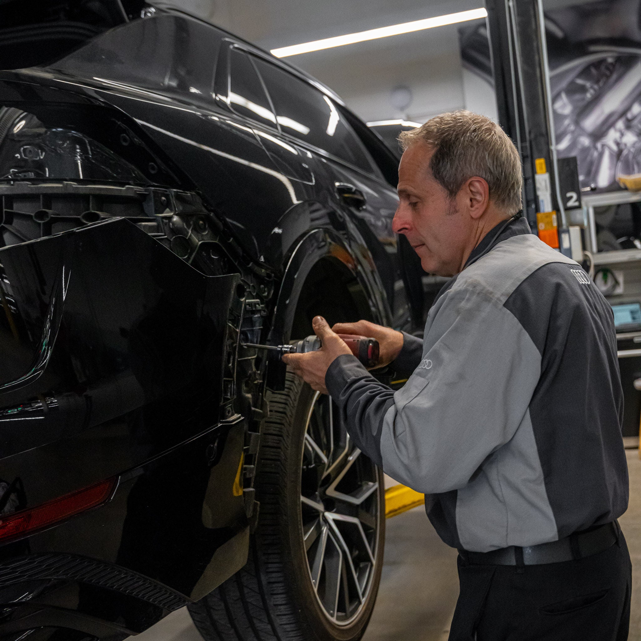 Un technicien du service Audi effectue l’entretien d’un véhicule. 