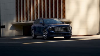 Three-quarter front view of the Audi Q9 in motion.
