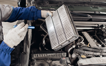 Service technician servicing air filter.