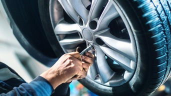 Worker adjusting car wheel.