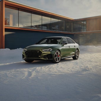 Audi A4 equipped with winter tires parked on a snow-covered road