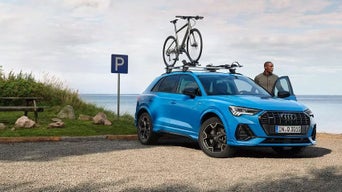 Audi vehicle parked near ocean. 