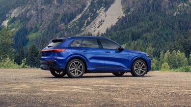 Rear profile of the Audi Q5, parked in front of the mountains.