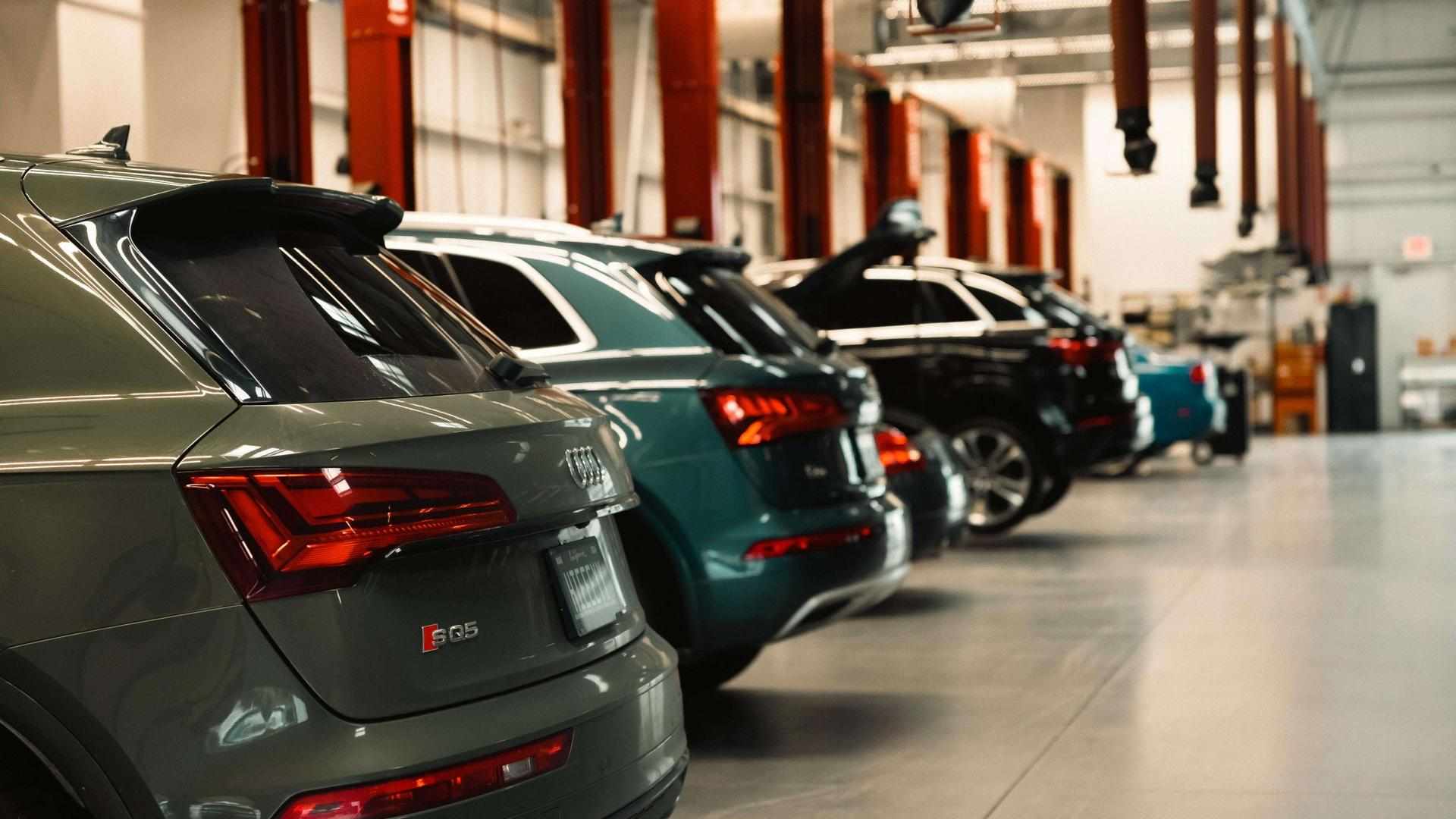 Lineup of Audi vehicles in a service center.