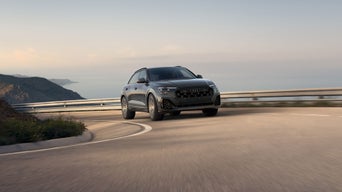 Front-view of the Audi SQ8 accelerating on a coastal road.