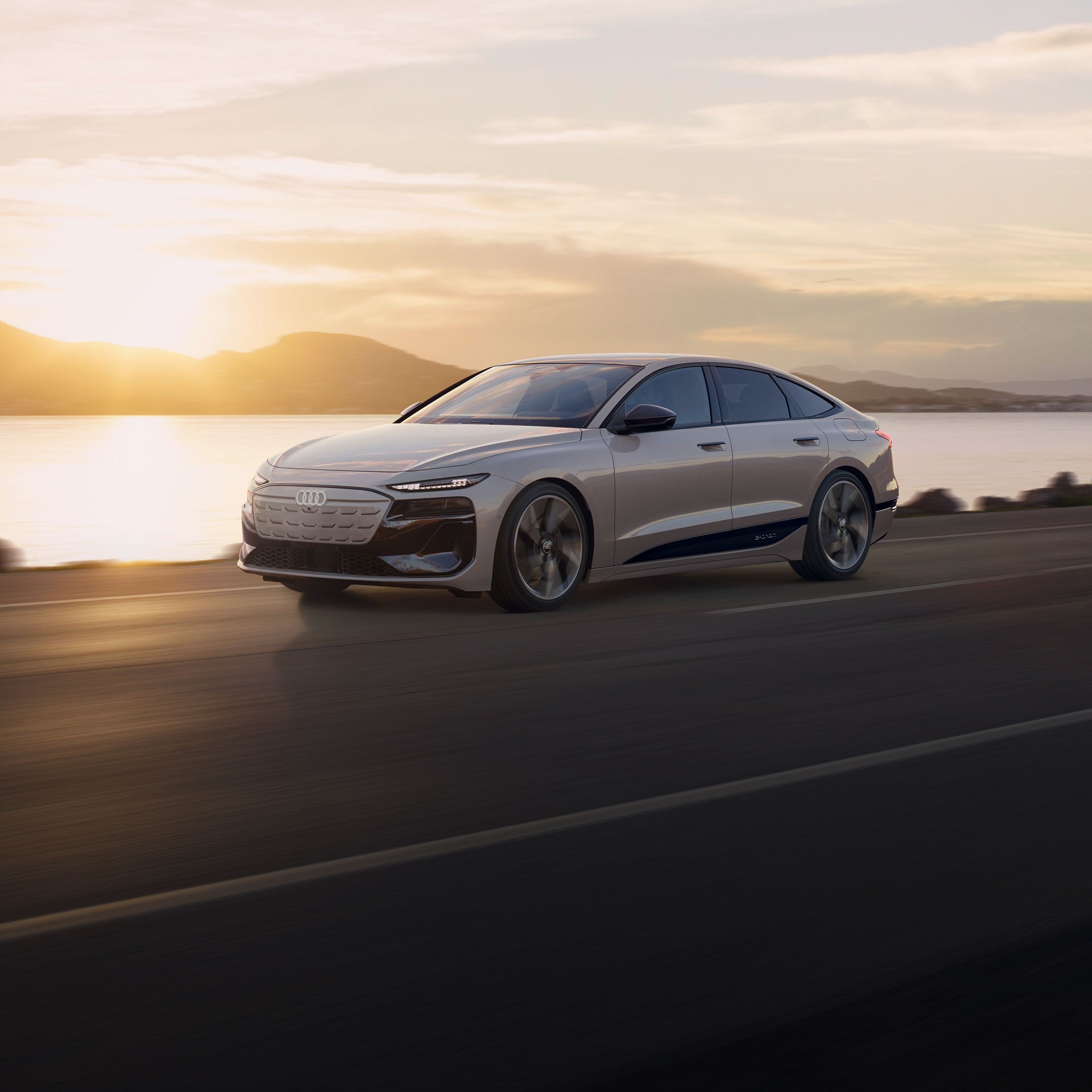 Three-quarter front-view of an Audi A6 e-tron accelerating on an oceanside road. 